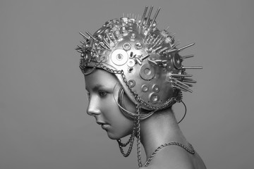 Futuristic woman in metal helmet with screws, nuts and chains