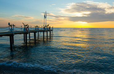 Obraz premium Wschód słońca nad morzem z pomostem w Kemer