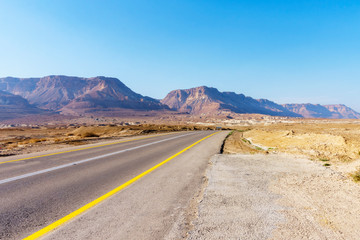 long road through the desert on a bright Sunny day