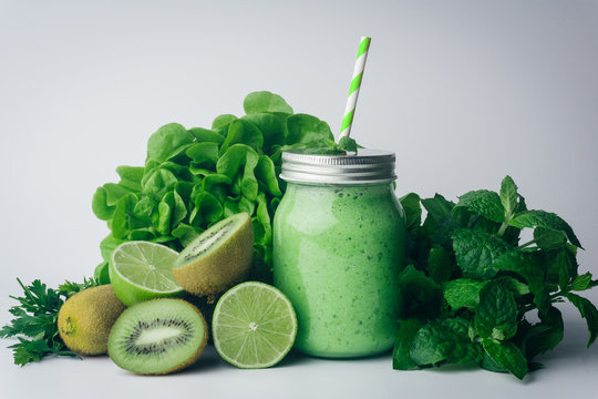 Green detox healthy smoothie from green fruit - avocado, salad, kale, lime, kiwi, mint. Alkaline diet concept. Vegan healthy alkaline food. Green fruit background. Flat lay