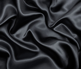 Smooth elegant dark grey silk or satin texture as abstract background. Luxurious background design