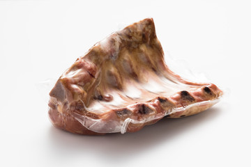 Smoked pork ribs vacuum packed on a white background