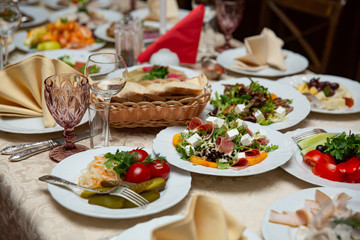 Fresh mix salad with ham, feta and mango on white plate. restaurant table setting