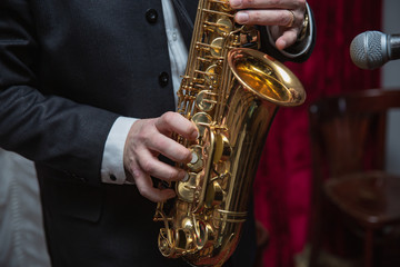 Saxophone player. Saxophonist hands playing saxophone. Alto sax player with jazz music instrument