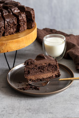 Slice of chocolate cake on gray plate with fork