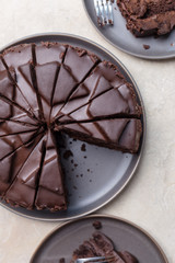 Slice of chocolate cheesecake on gray plate, above view over a gray concrete background