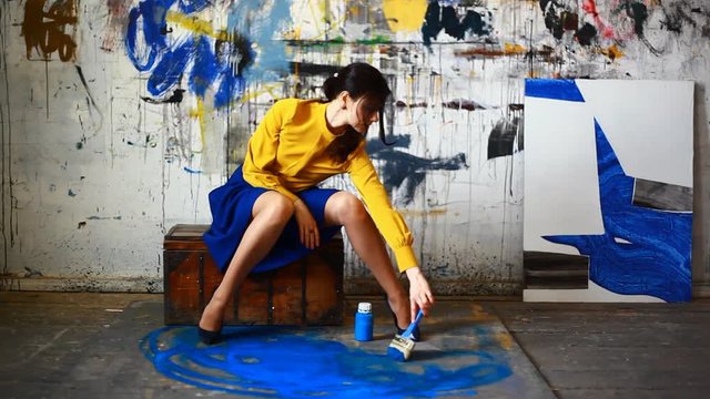 Artist's painting process .Girl artist with paintbrush at painting process