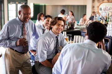 Group Of Businessmen Meeting For After Works Drinks In Bar
