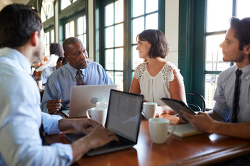 Business Team Having Informal Meeting Around Table In Coffee Shop