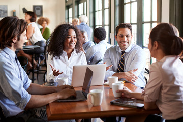 Business Team Having Informal Meeting Around Table In Coffee Shop