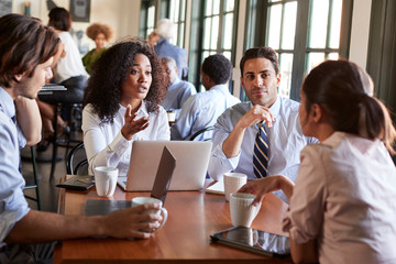 Business Team Having Informal Meeting Around Table In Coffee Shop