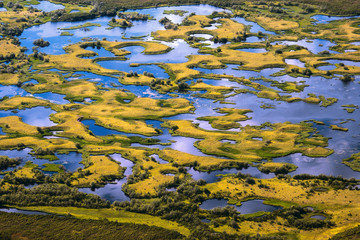 Fototapeta na wymiar Top view of the oxbow lake and many small islands. Aerial photography. Picturesque summer tundra. Amazing landscapes of the Arctic. Chukotka, Siberia, Far East of Russia.