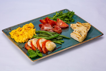 Italian snack omelette with aspagagus, tomato, arugula, salami, prosciutto and toast