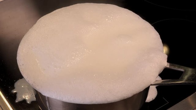 Cook natural organic milk, boil the milk in pots, milk that is about to overflow, overflowing milk