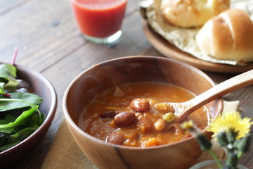 ナチュラルな木の上の野菜と豆のミネストローネのスープ