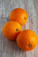 top view of three oranges on white wooden background