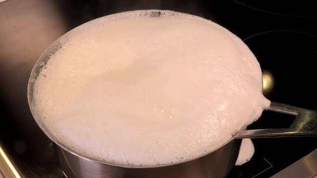 Cook natural organic milk, boil the milk in pots, milk that is about to overflow, overflowing milk