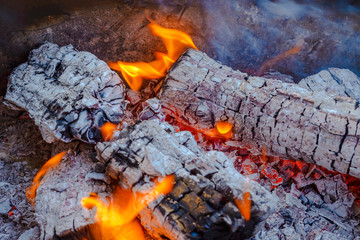 Burning coals from logs on the fire. The wind blows the burning fire