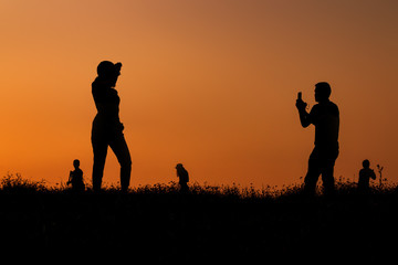 Fototapeta na wymiar silhouettes of people taking pictures with smartphone
