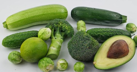 Vegetables and fruits of green color on the white background. Healthy food.
