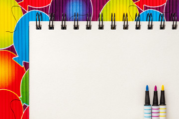 Top view mockup. Open sketchbook, notebook. Creative desk. Pattern with colorful balloons and CMYK markers