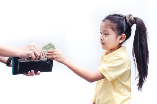 Young girl receive american bank note from parent.