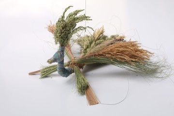 Handmade crafts from dry summer herbs in the form of birds, bringing luck, a talisman for home and family, closeup shot on a white background © gohomespivak