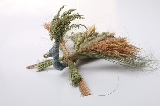 Handmade crafts from dry summer herbs in the form of birds, bringing luck, a talisman for home and family, closeup shot on a white background