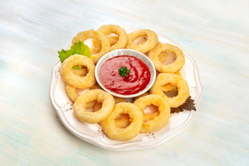 A plate of squid rings with a red sauce and a place for text