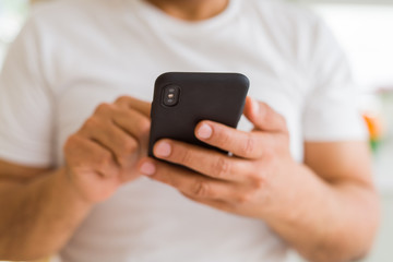 Close up of middle age man hands using smartphone at home