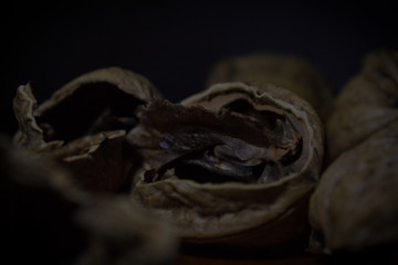 Shallow depth of field macro shot of bunch of empty walnut shells in the darkness