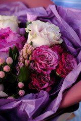 pink and purple bouquet of roses. woman preparing bouquet in flower shop. Close up. Mother's Day and Valentine's Day concept