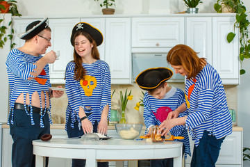 Photo session - friendly family. The family cooks together. Husband, wife and their children in the kitchen. Family kneads dough with flour. Prepare the dough in the kitchen.