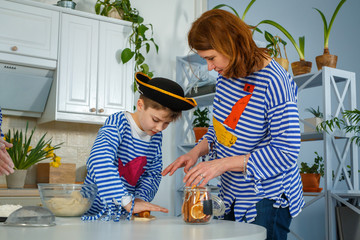Photo session - friendly family. The family cooks together. Husband, wife and their children in the kitchen. Family kneads dough with flour. Prepare the dough in the kitchen.
