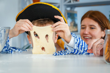 Photo session - friendly family. The family cooks together. Mom and son knead the dough with flour. Prepare the dough in the kitchen.