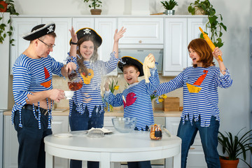 Photo session - friendly family. The family cooks together. Husband, wife and their children in the kitchen. Family kneads dough with flour. Prepare the dough in the kitchen.