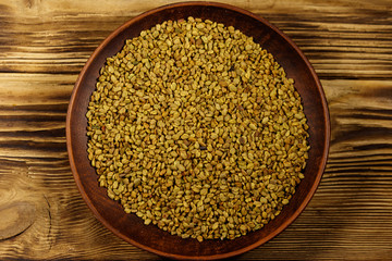 Fenugreek seeds in ceramic plate on wooden table