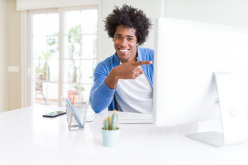 African American man working using computer very happy pointing with hand and finger