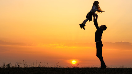 Silhouettes of happy child rushes into hands of father.