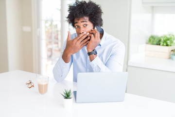 African American business man talking on the phone cover mouth with hand shocked with shame for mistake, expression of fear, scared in silence, secret concept