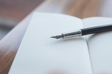 A fountain pen on top of a notebook
