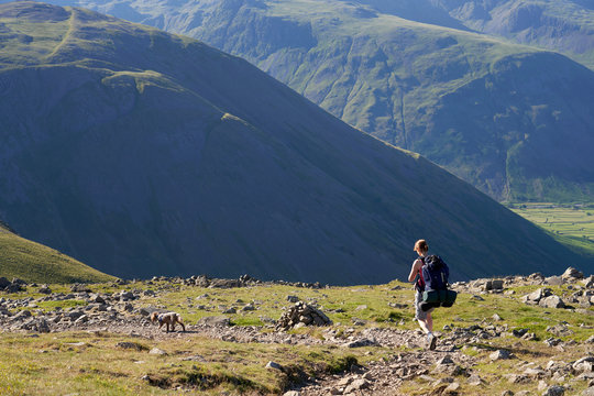 A female hiker backpacking In the English Lake District with views of Kirk Fell and Mosedale.