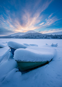Boats covered by heavy snow with kellostapuli and Yll&auml;s fell in the background in &Auml;k&auml;slompolo, Kolari, Finland