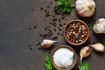 Black, red and white peppersalt, salt, garlic in a wooden bowl . Classic spices for cooking. View from above.