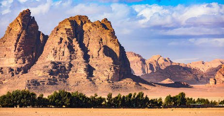 Beautiful landscape consisting of rocky mountains and a green oasis in the middle of the Wadi Rum...