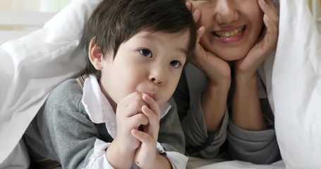 Mother and child little boy relaxing and playing blanket in the bed ,Mother's day, People family lifestyle concept.