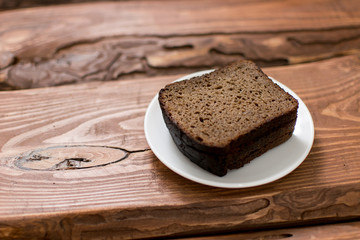 Slices of black bread on a wooden background.