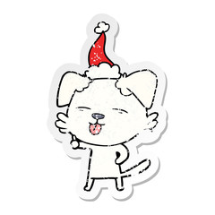 distressed sticker cartoon of a dog sticking out tongue wearing santa hat