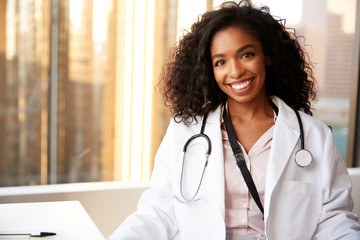 Portrait Of Smiling Female Doctor Wearing White Coat With Stethoscope In Hospital Office - Powered by Adobe