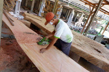 people's activities are smoothing wood with a machine